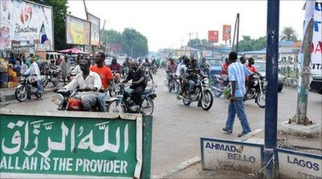 Street scene in Maiduguri with a sign saying "Allah is the provider"