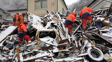 Rescue workers searching debris in Japan