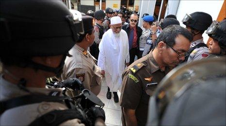 Armed anti-terror police commandos escort Abu Bakar Bashir at Jakarta court on March 14, 2011