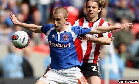 Carlisle United striker Paddy Madden holds off Brentford's Robbie Neilson