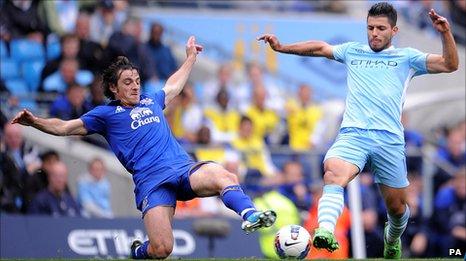 Sergio Aguero (right) and Leighton Baines battle for the ball