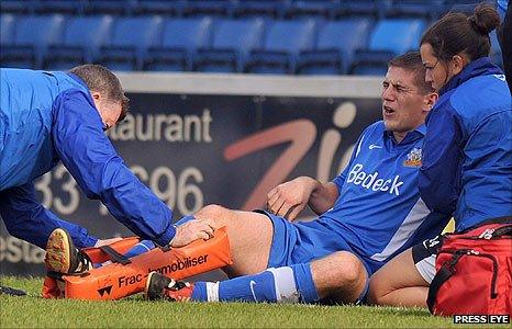 Mark Haughey receives medical attention after breaking his leg at Mourneview Park