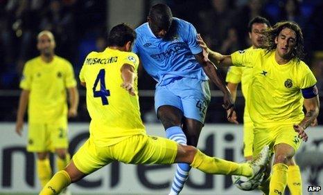 Manchester City's Yaya Toure shoots to score next to Villarreal's Argentine defenders Gonzalo Rodriguez (right) and Mateo Musacchio