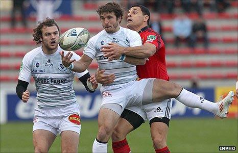 Marc Andreu of Castres is tackled by Munster's Dougie Howlett