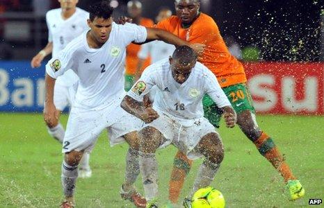 Libya and Zambia players struggle for the ball in rain-soaked Bata