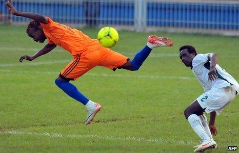 Ivory Coast's Angoua Brou (R) looks on at Sony Ela Nguema's Santiaco Ela