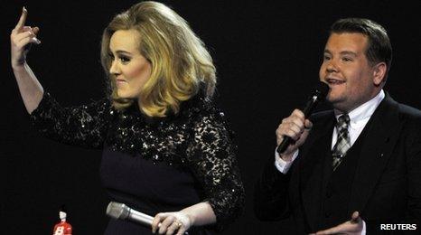 Adele and James Corden on stage at the Brit awards.