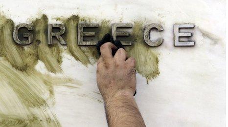 Graffiti is wiped off a Greek sign