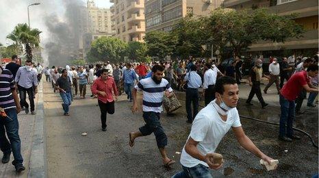 Egyptian pro-Morsi protesters run from police in a street leading to Rabaa al-Adawiya protest camp in Cairo on August 14, 2013
