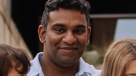 Gihan Ganesh, wearing an open-necked blue shirt, looks straight into the camera.