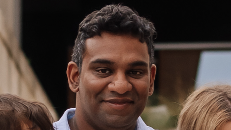 Gihan Ganesh, wearing an open-necked blue shirt, looks straight into the camera.