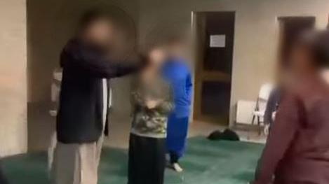 An image taken from a video of a man slapping a child across the face at a mosque in West Yorkshire 