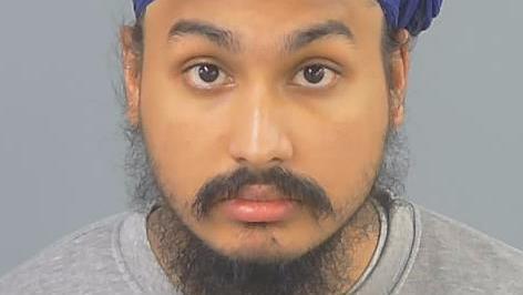 Custody photo of Vickrum Digwa, a man with a beard, a grey jumper and a purple turban looking to the camera.