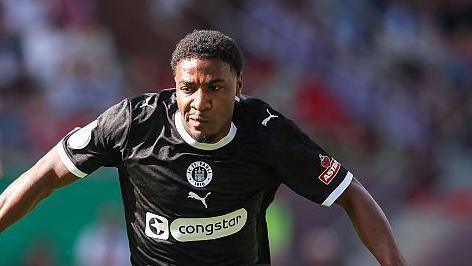 St. Pauli player Oladapo Afolayan runs with the ball at his feet in a match against Eintracht Norderstedt.