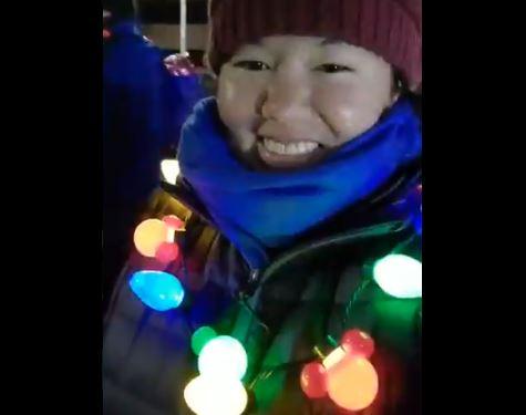 Patricia in her multicoloured flashing garland smiling to the camera