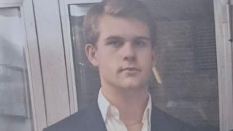 Achille Osvaldo Giovanni Barosi wears an open-neck shirt and blazer.