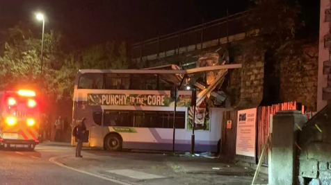 The top deck of a bus looks crushed by the impact of the crash into the railway bridge