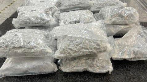 Vacuum sealed white plastic bags, that are allegedly full of cannabis, laid out on a table