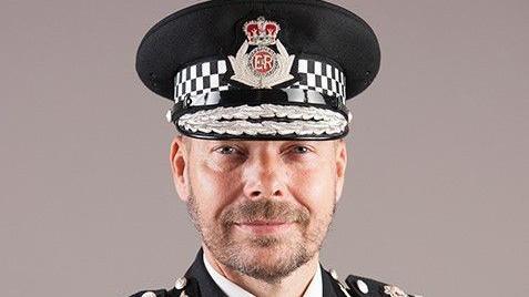 Headshot of Rod Hansen in full uniform, including a hat with the crest for Gloucestershire Police on it