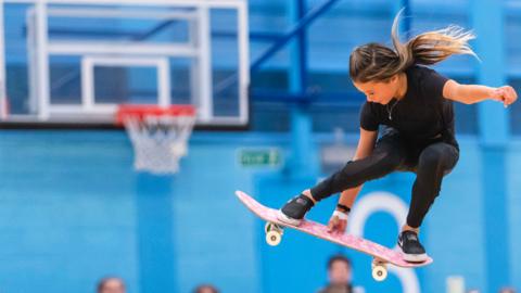 Skateboarder Sky Brown in mid-air on her board.