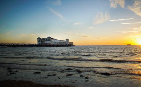 A view of the Grand Pier across the sea, during a sunset.