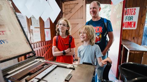 Children looking at printing press