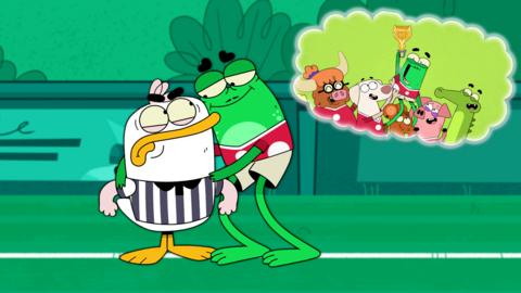 Duck and Frog are stood on a football pitch whilst a thought bubble is on the top right of the screen with Frog holding up a trophy.