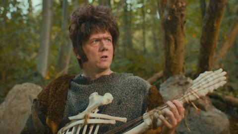 A caveman is playing a guitar made of a skeleton