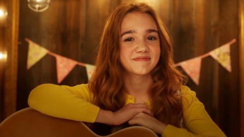 Holly Hobbie smiles with her guitar.