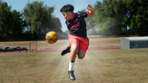 Image of Lucas performing a football trick on the pitch.