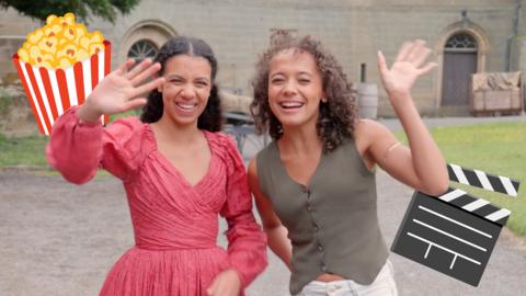 Sienna and Carys wave at the camera in front of the castle from The Lady Grace Mysteries.