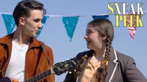 Irene smiles at a boy, they are on stage and he is holding a guitar.