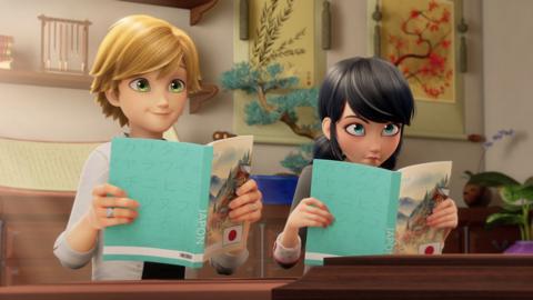 Animated boy and girl sit at a desk whilst reading books with green covers.