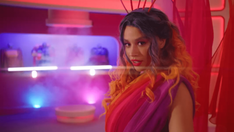 Nova is wearing an orange and purple dress