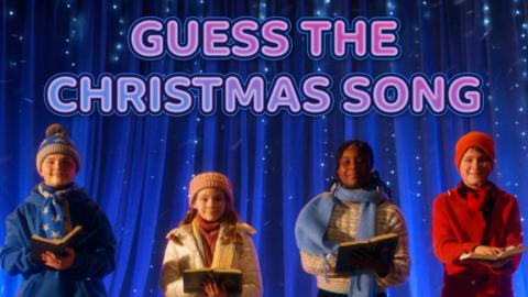 Four children are singing Christmas carols below text which says "Guess the Christmas song"