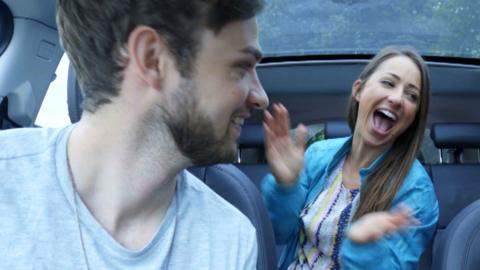 Three people in a car laughing.