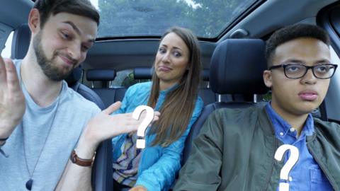 Three people in a car laughing.