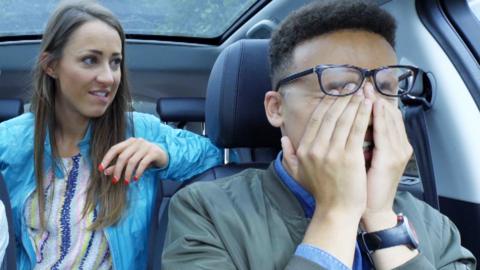Three people in a car looking surprised.