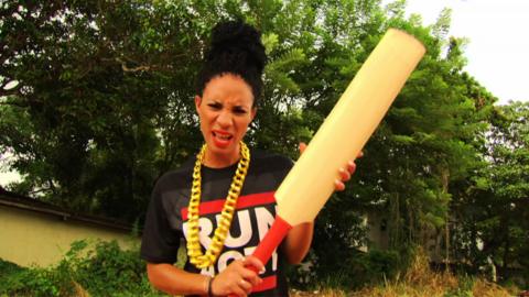 A woman holds a cricket bat up in confusion.