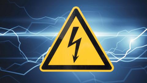 An electrical sign with electricity behind it.