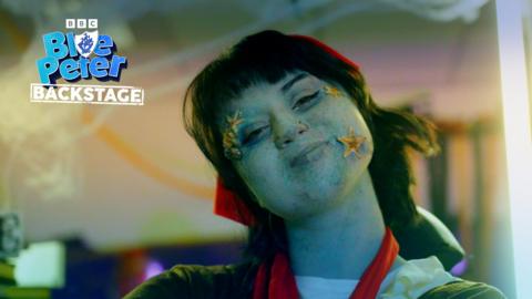 Abby from Blue Peter wearing a pirate's bandana, her face is blue with special effects make up and she is wearing starfish and sea shells on her face.