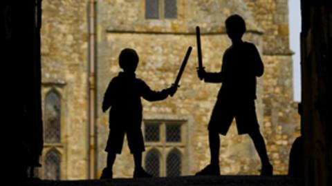 Two children in shadows playing knights