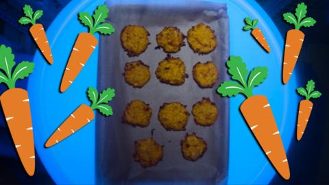 Some cookies on baking tray surrounded by cartoon carrots.