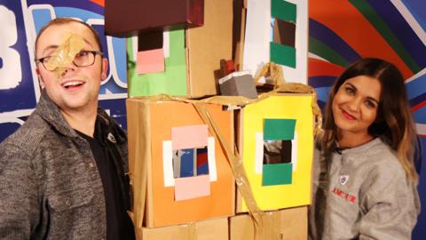 Joe Tracini and Lauren Layfield from The Dengineers, with a cardboard doll's house.