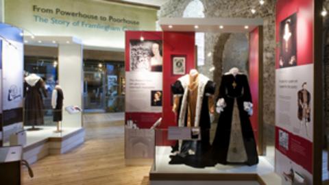 A bright exhibition space filled with various historical costumes