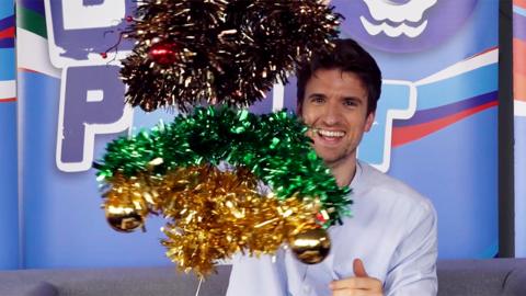 Greg James with an advent crown, covered in tinsel.
