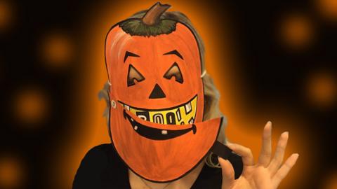 A creepy Halloween pumpkin mask on a black background.