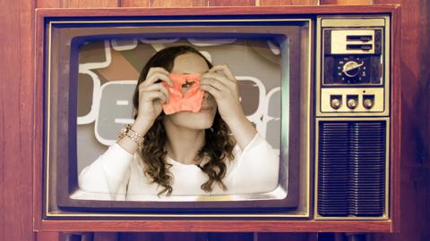 Isabel Clifton, who plays Hetty Feather, holding a slice of ham up to her face.
