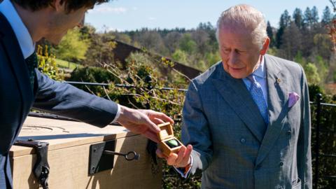 King Charles III receives a Green Blue Peter badge from presenter, Joel.