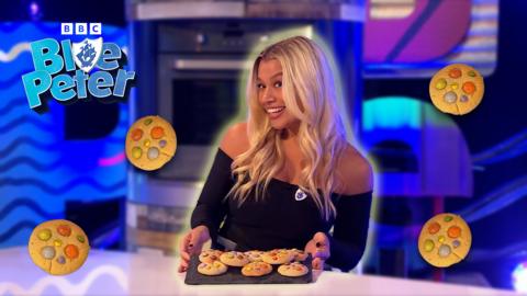 Molly Rainford is holding a tray of biscuits whilst smiling.